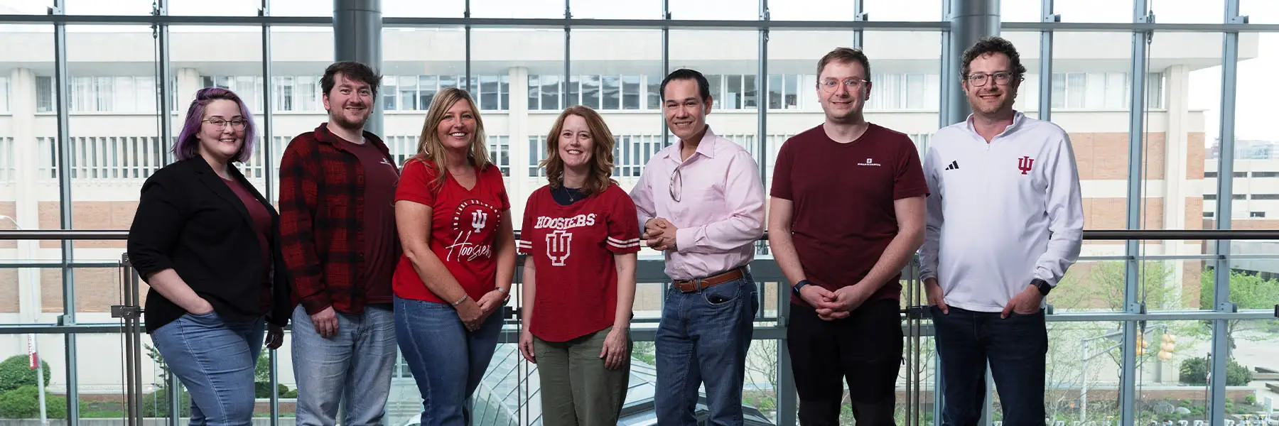 Seven people standing in front of a clear glass wall