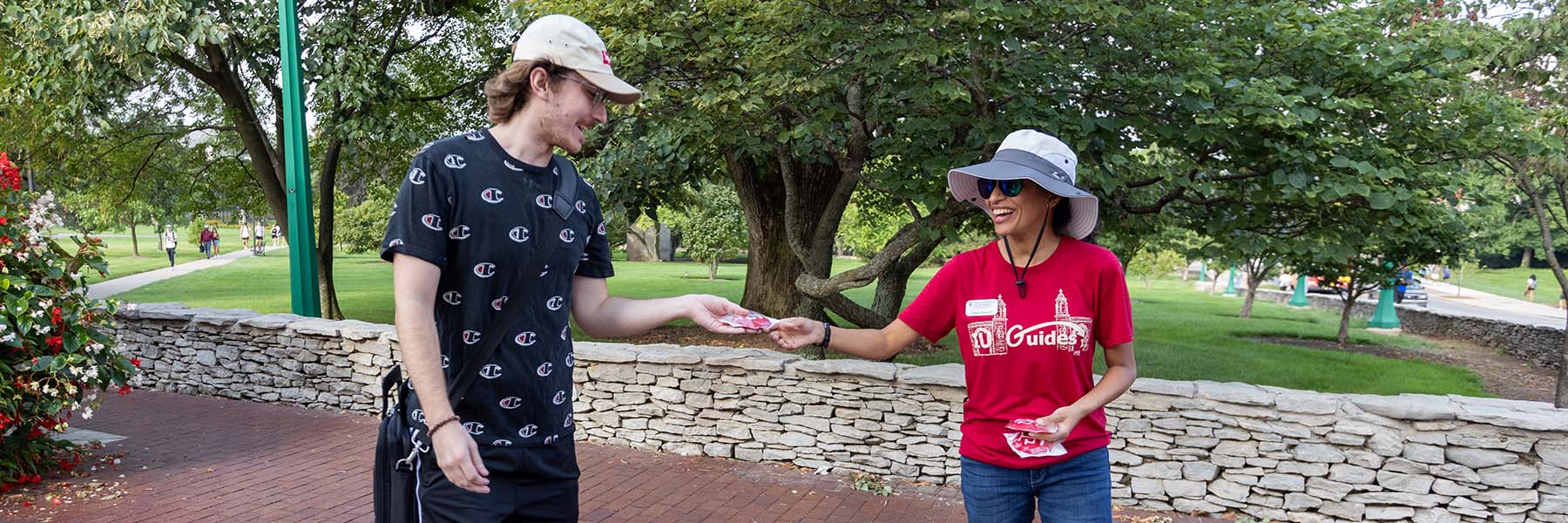 An IU employee gives an IU cookie to a student