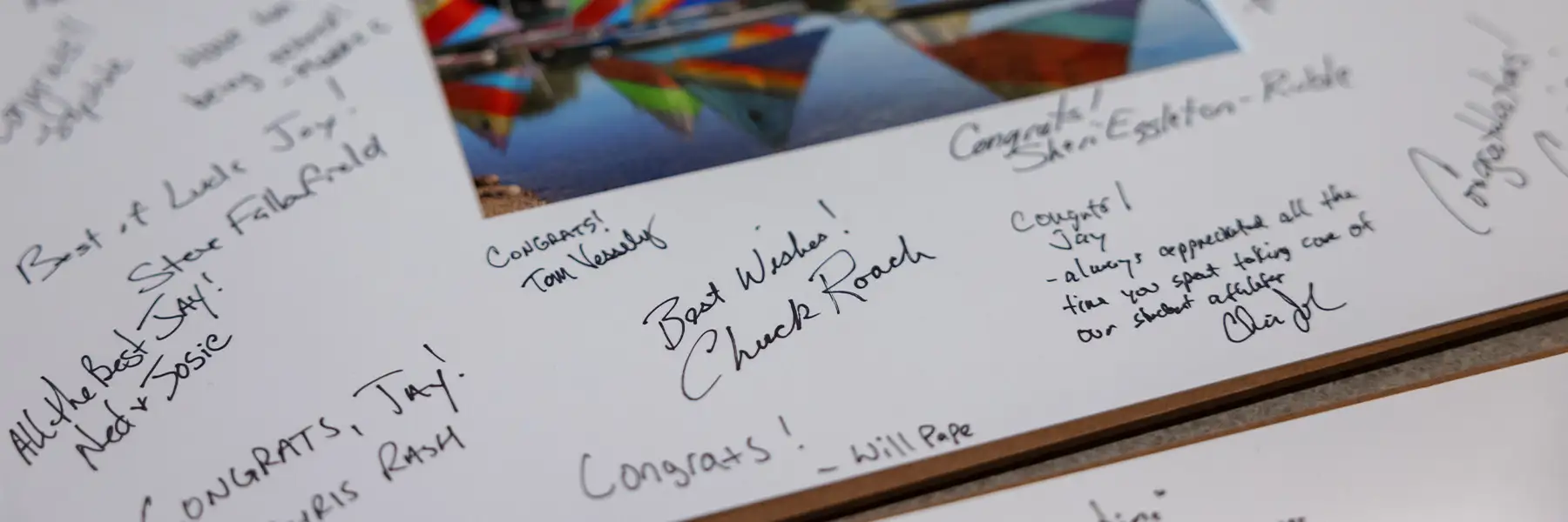 A picture frame corner that includes written well wishes for retirement from peers.