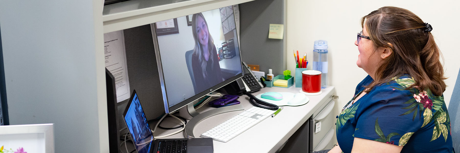 A woman has a remote conversation with a teammate